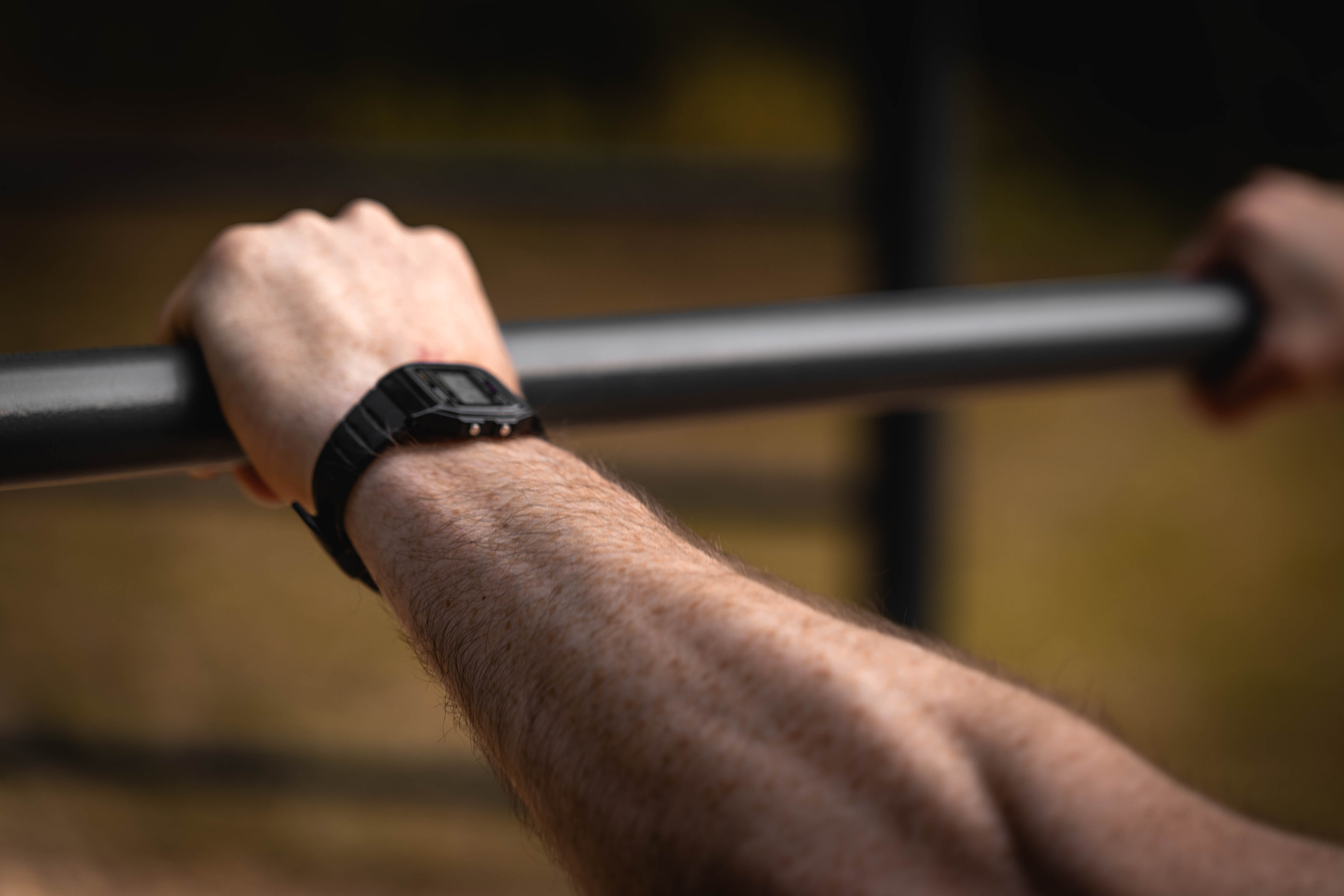 Close-up of hand gripping a pull-up bar during outdoor workout